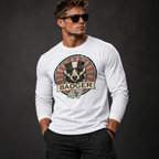 Athletisches männliches Model mit Sonnenbrille trägt ein weißes Badger 47 Longsleeve mit Vintage-Grafik und schwarze Hose vor anthrazitfarbenem Studiohintergrund.