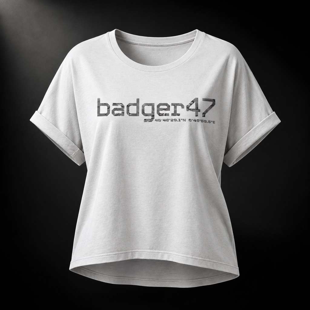 Weißes Badger 47 Multicam Grau Damen-T-Shirt mit weitem Schnitt, gerollten Ärmeln, längerem Rückensaum und grauem Camouflage-Logo im Studiolicht
