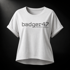 Weißes Badger 47 Multicam Grau Damen-T-Shirt mit weitem Schnitt, gerollten Ärmeln, längerem Rückensaum und grauem Camouflage-Logo im Studiolicht
