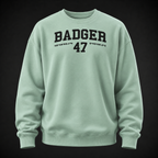 Oversize Sweatshirt in Misty Jade mit schwarzem BADGER-47-Print, frontal als Ghost-Mannequin vor dunklem Studiohintergrund dargestellt.
