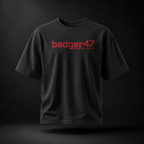 Schwarzes Badger 47 Strive Oversized T-Shirt mit rotem Logo-Print auf der Vorderseite und natürlichem Faltenwurf
