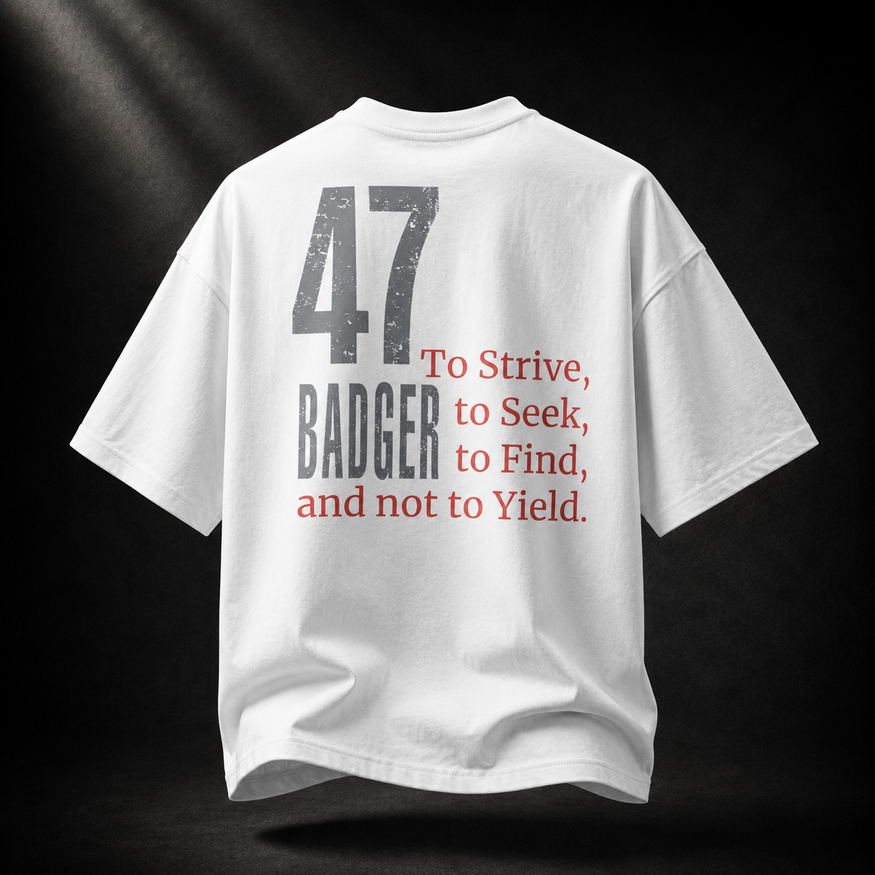 Rückseite des weißen Badger 47 Strive Oversized T-Shirts mit grauer 47, BADGER-Schriftzug und rotem Never-Yield-Zitat
