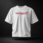 Weißes Badger 47 Strive Oversized T-Shirt mit rotem Logo-Print auf der Vorderseite, schwebend im dunklen Studiolicht
