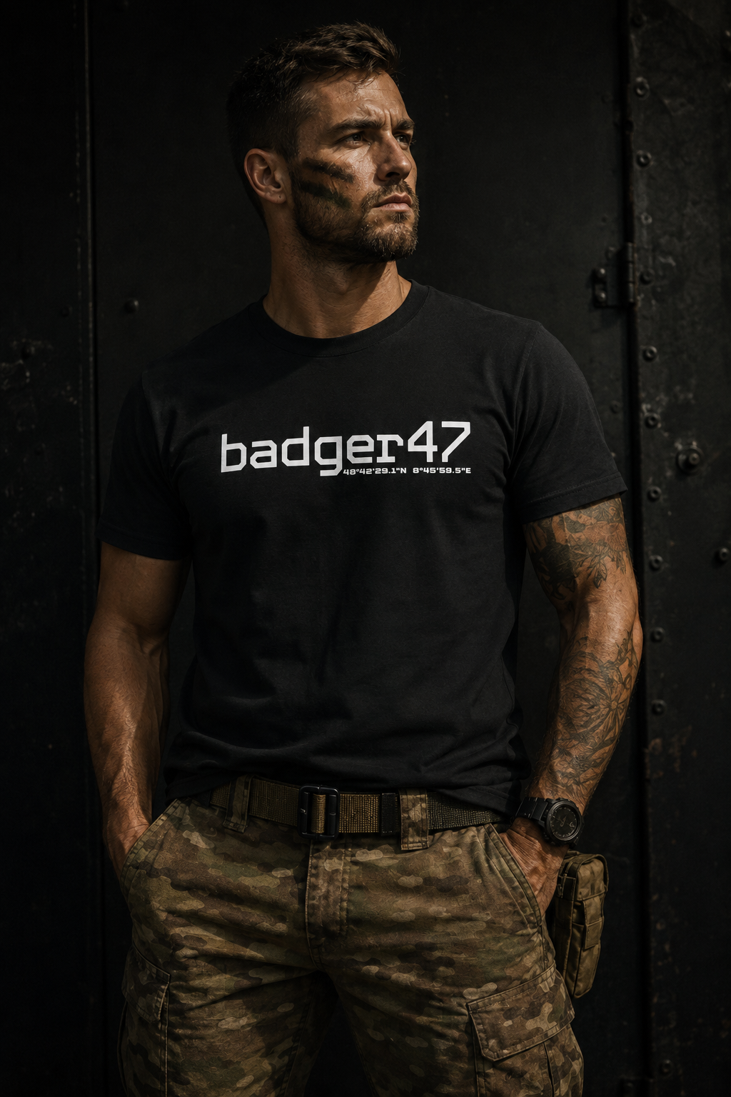 Mann im militärisch inspirierten Look trägt ein schwarzes badger47 Bio T-Shirt mit weißem Coordinates-Print
