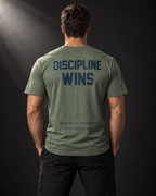 Rückansicht eines athletischen Männermodels im khakifarbenen BADGER47 T-Shirt mit „Discipline Wins“-Print.