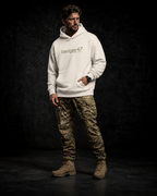 BADGER47 FIELD Boxcut Hoodie in White Sand mit Multicam-Logo, getragen mit Multicam-Hose im dunklen Studio