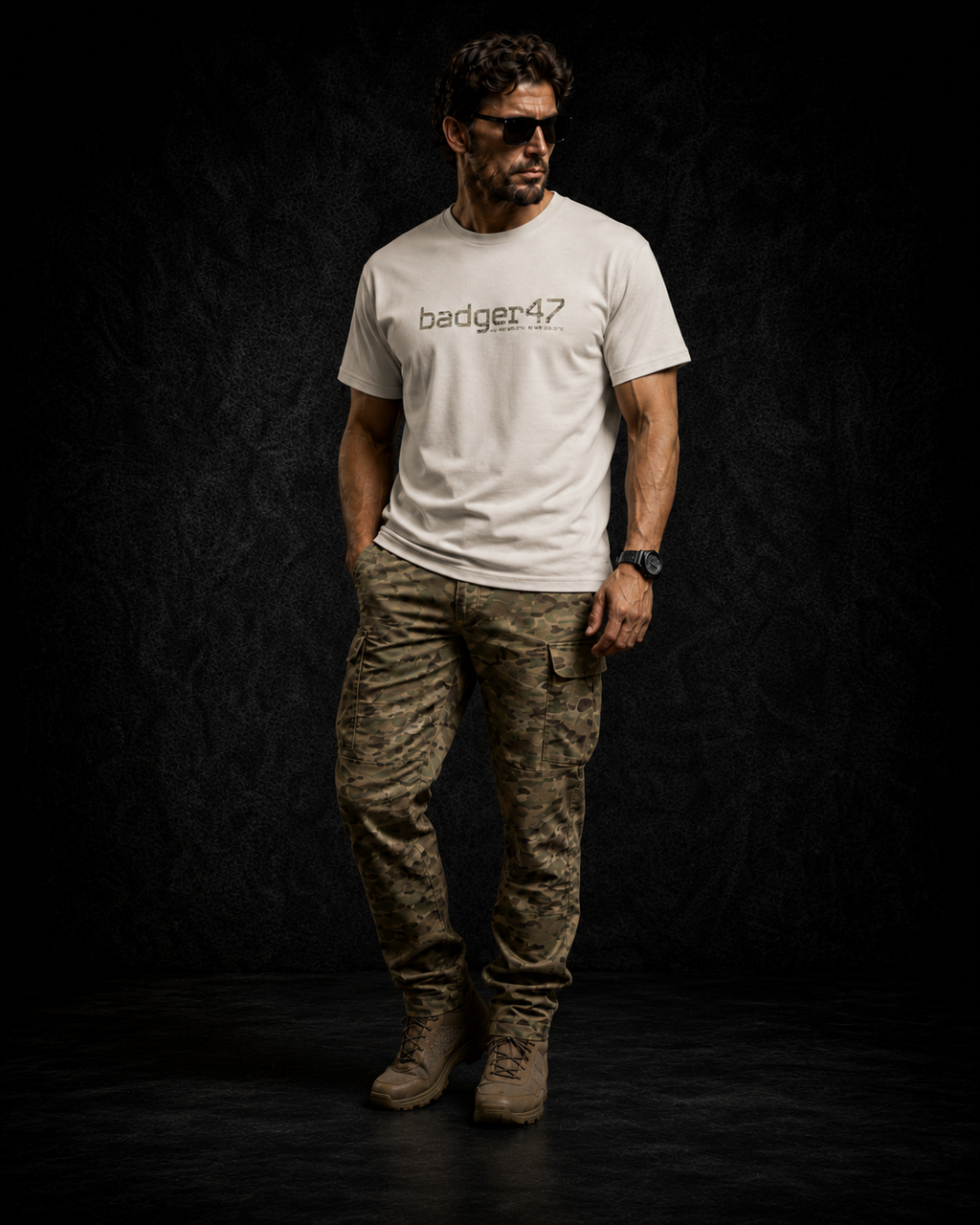 BADGER47 FIELD Organic T-Shirt in Natural Raw mit Multicam-Logo, getragen mit Multicam-Hose im dunklen Studio
