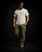 BADGER47 FIELD Organic T-Shirt in Off White mit Multicam-Logo, getragen mit Multicam-Hose im dunklen Studio
