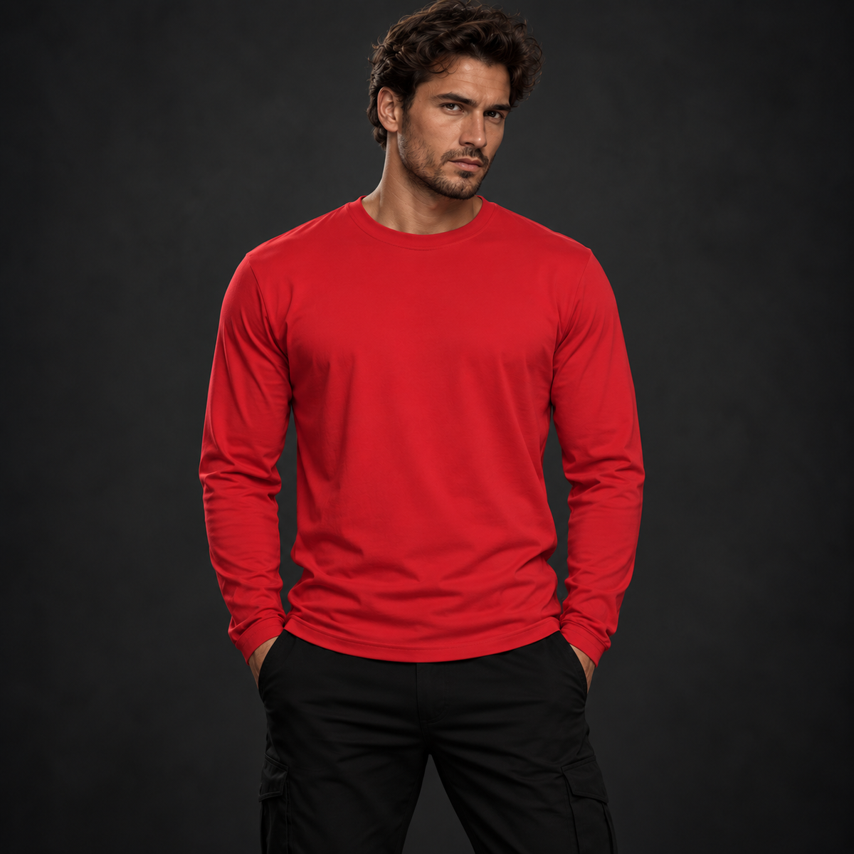 Athletisches männliches Model trägt ein rotes Badger47 Longsleeve ohne Frontprint und schwarze Hose vor anthrazitfarbenem Studiohintergrund.