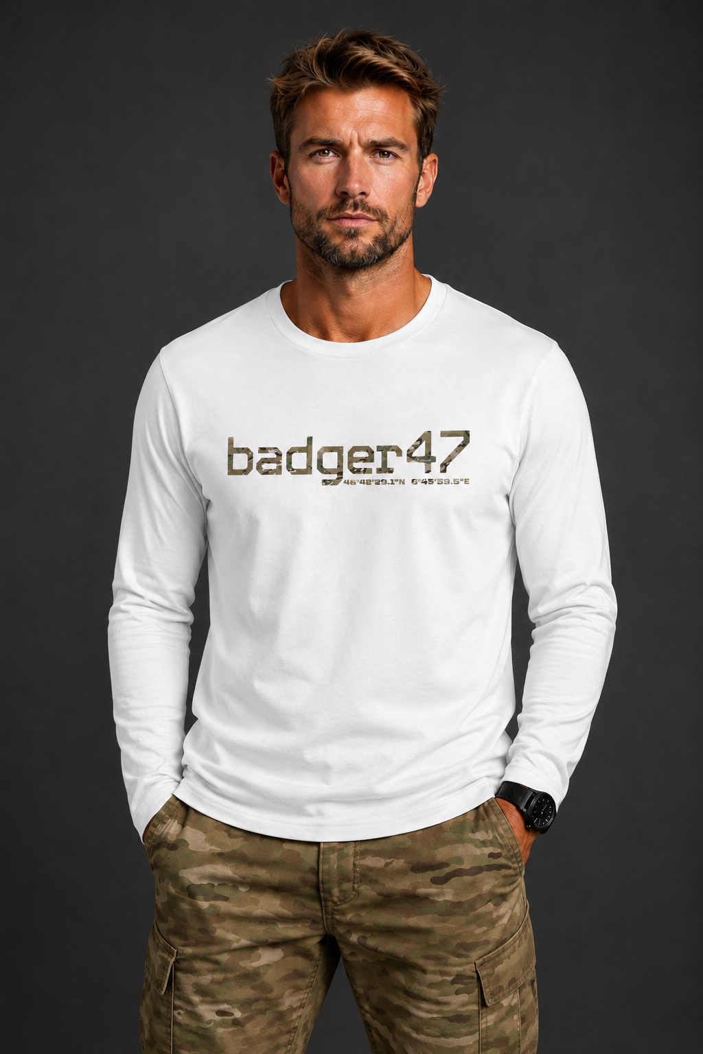 Dunkelblondes Männermodel mit weißem badger47 Organic Longsleeve und Multicam-Hose vor anthrazitfarbenem Studiohintergrund