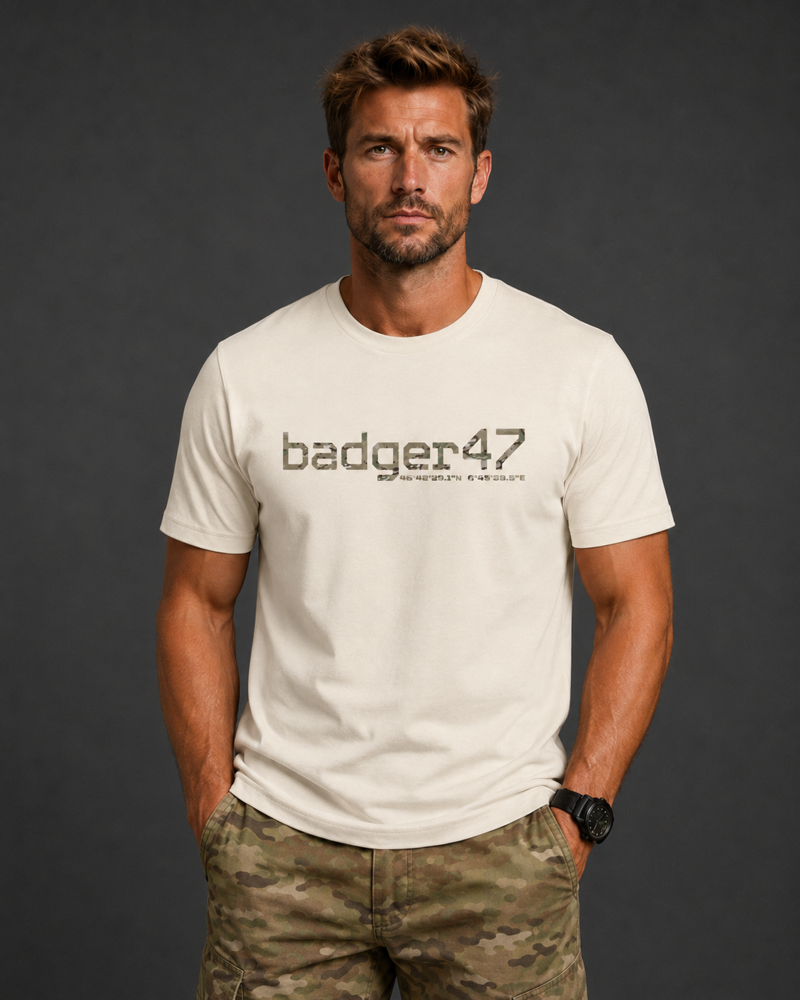 Dunkelblondes Männermodel mit badger47 Organic T-Shirt in Natural Raw und Multicam-Hose vor anthrazitfarbenem Studiohintergrund