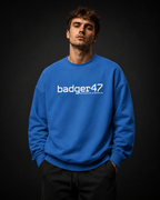 Männliches Model trägt das Badger47 Oversize Sweatshirt in Royal Blue mit weißem Frontprint und Koordinaten-Detail in einem lockeren SOF Streetwear-Look vor dunklem Studiohintergrund.