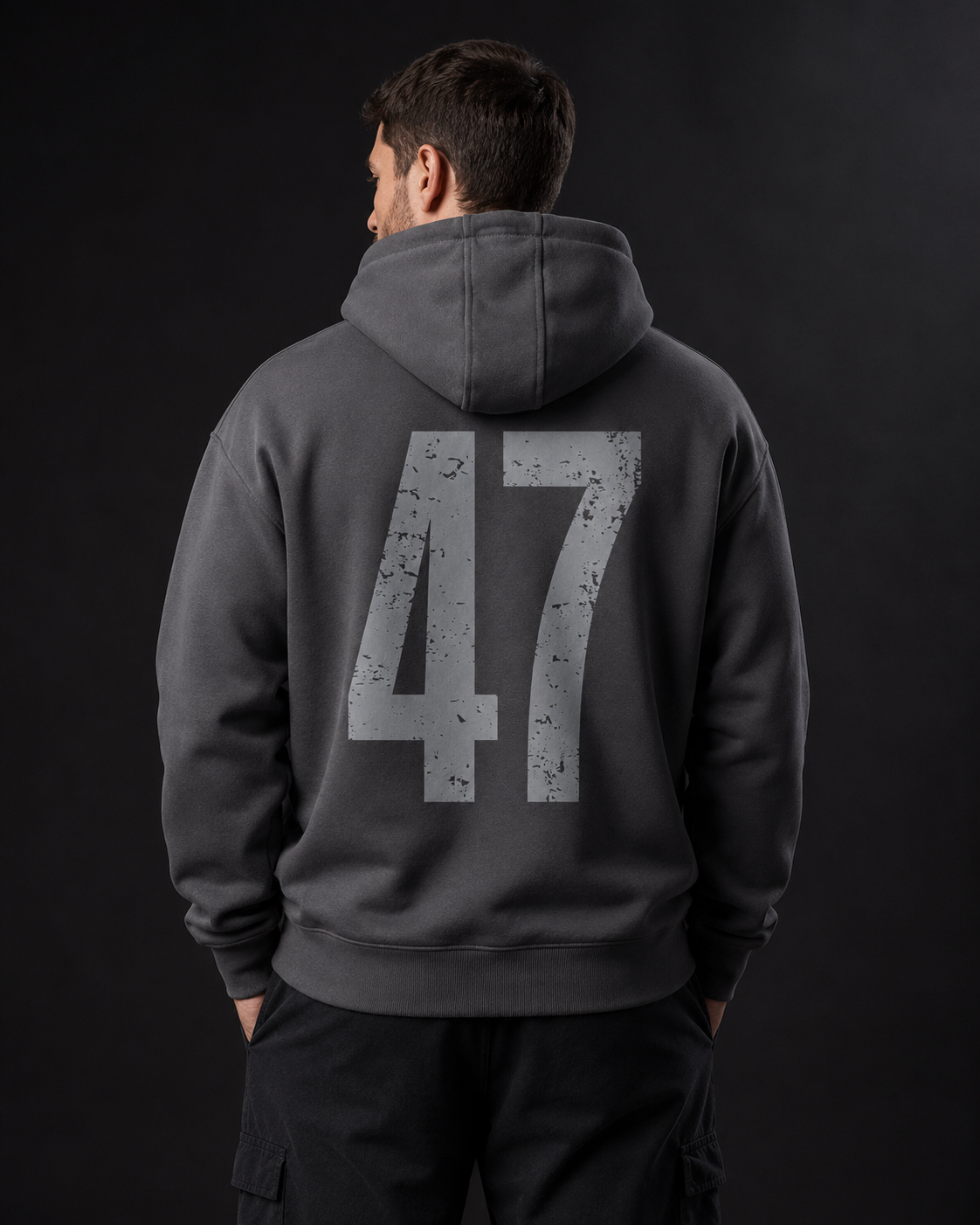 Männermodel trägt einen dunkelgrauen badger47 Oversized Hoodie mit großem 47-Print auf dem Rücken
