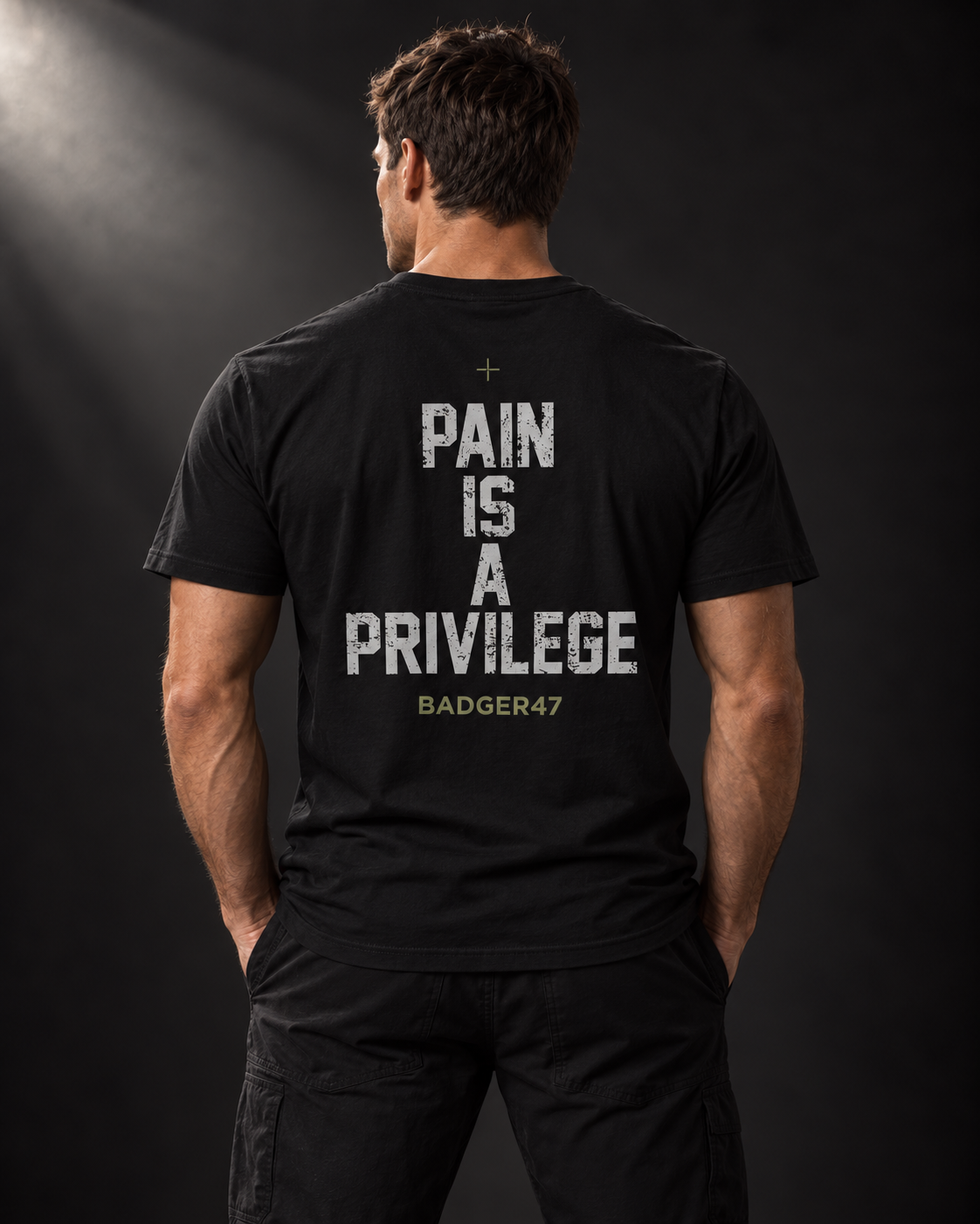 Rückansicht eines athletischen Männermodels im schwarzen BADGER47 T-Shirt mit „Pain Is A Privilege“-Print.